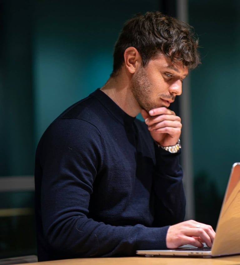 a man sitting at a desk with a laptop computer