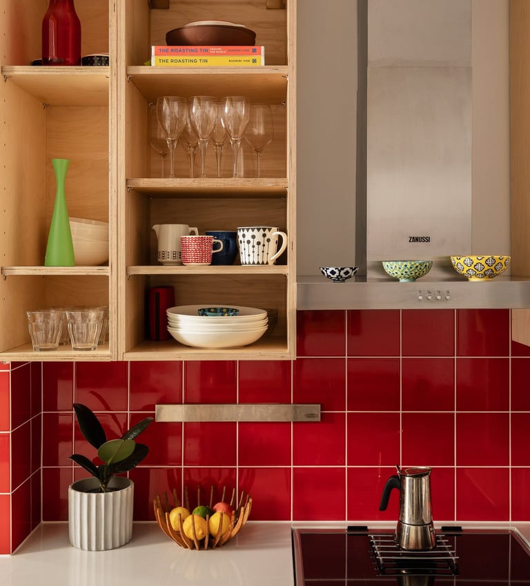 Close up of kitchen ply cupboards and red splashback