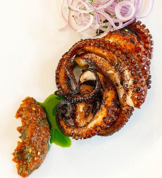 Grilled octopus with dried tomato-herbs sauce & basil oil - prepared by Villa Eats in Naxos