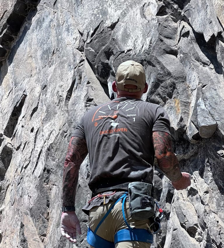 Carl Gregory is climbing a rock face on a mountain