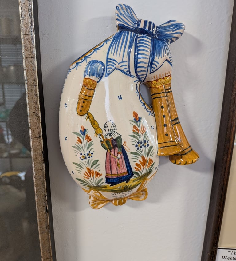 Vintage Quimper ceramic bagpipe wall hanging featuring a hand-painted Breton woman and floral motifs.