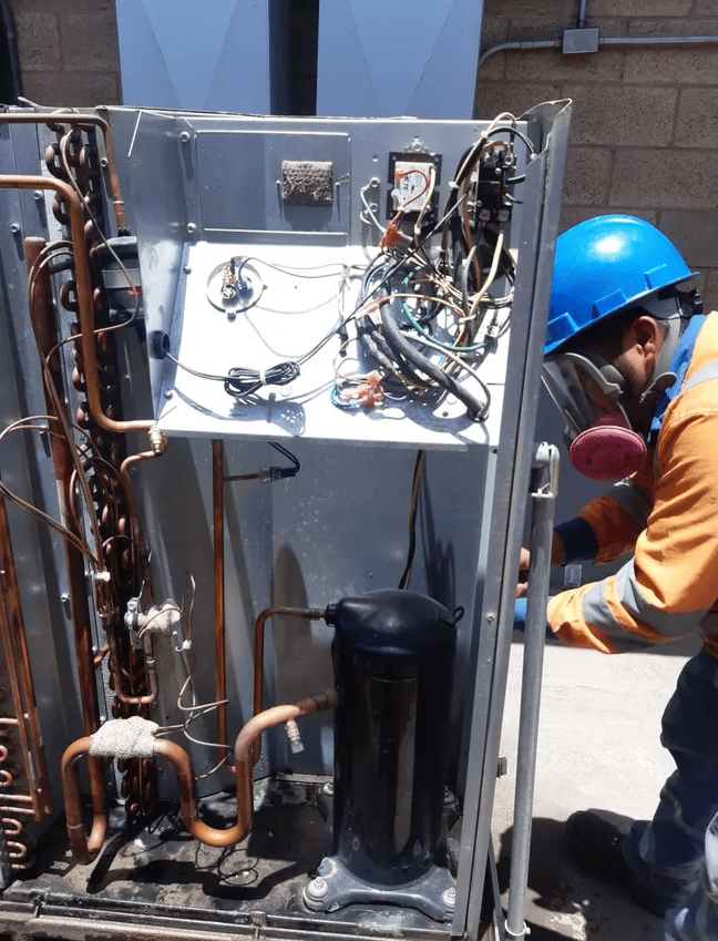 hombre reparando equipo de aire acondicionado