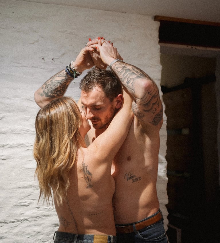 Couple tatoué s’embrassant lors d’une séance photo de couple intimiste