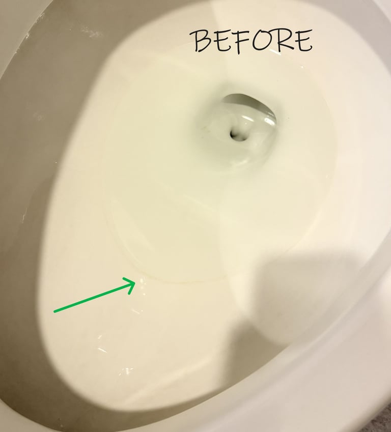 Toilet bowl with a hard water ring highlighted by a green arrow before cleaning
