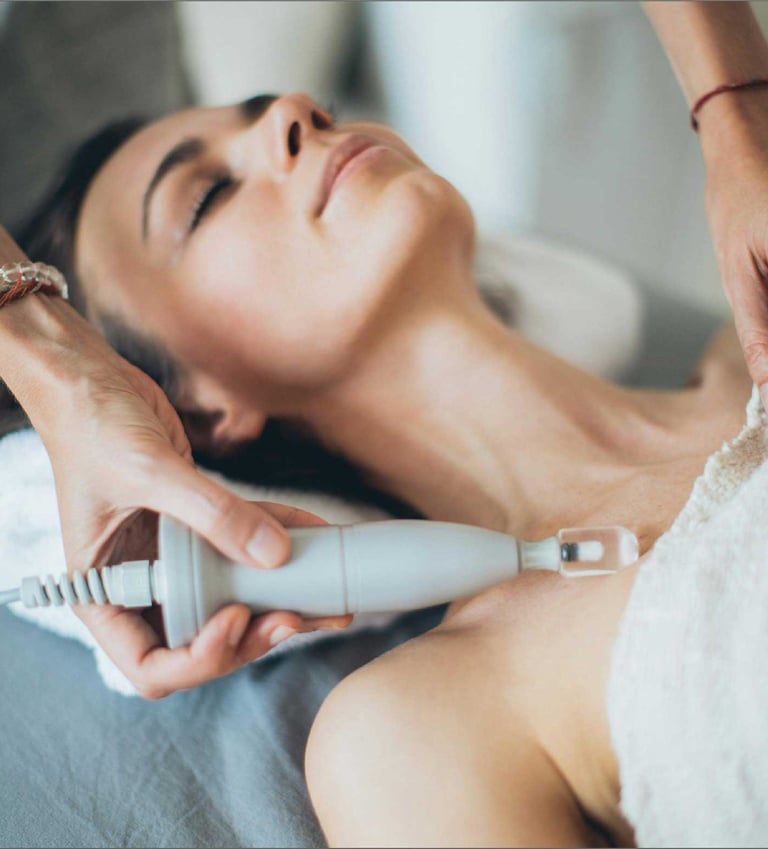 mujer recibiendo un tratamiento de belleza con aparatos holistico y natural en ibiza
