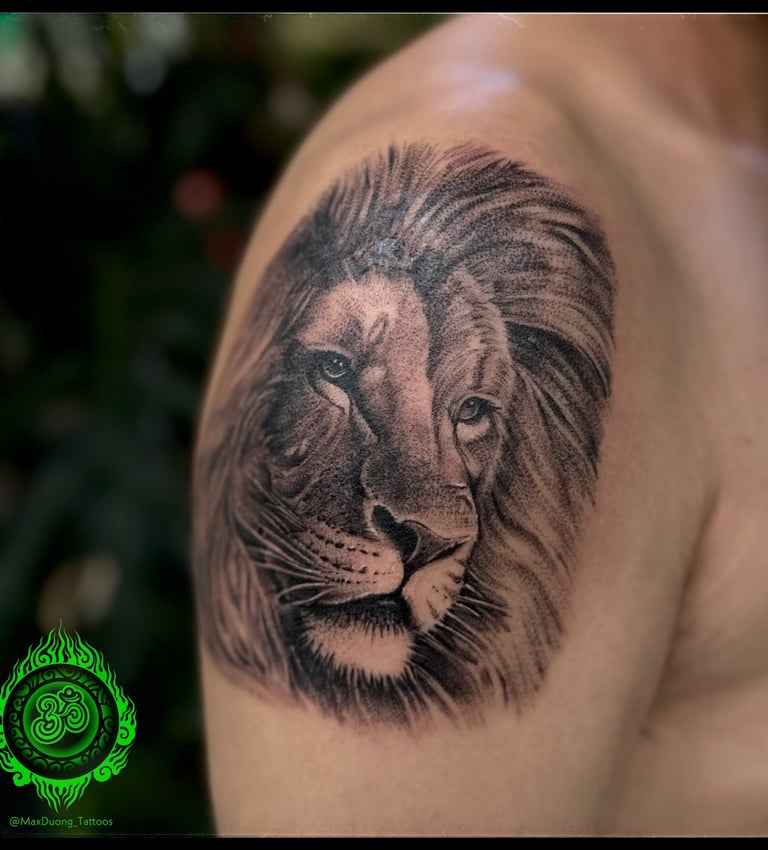 Detailed realistic tattoo of a lion's face on the upper arm