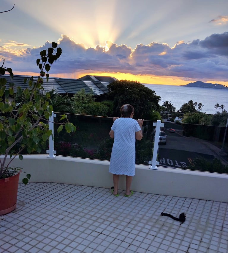 Photo of an old lady watching a sunset with god rays