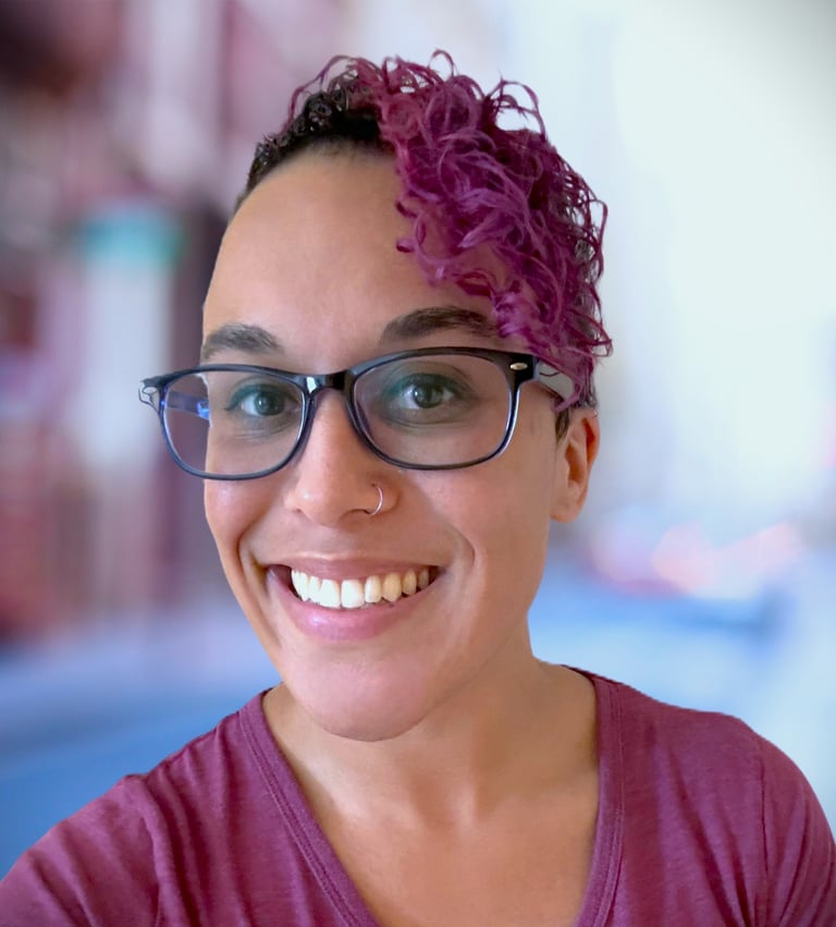 a woman with glasses and a purple shirt