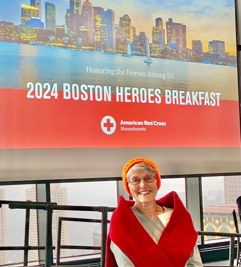 Susan Baur posed before a banner that reads, "2024 Boston Heroes Breakfast."