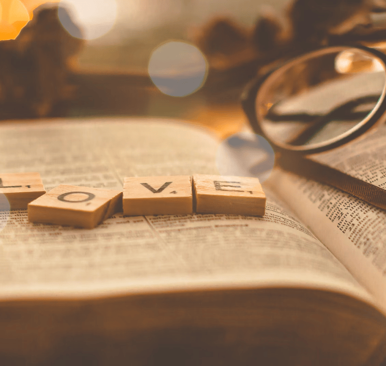 scrabble pieces spelling out the word love sitting on a book
