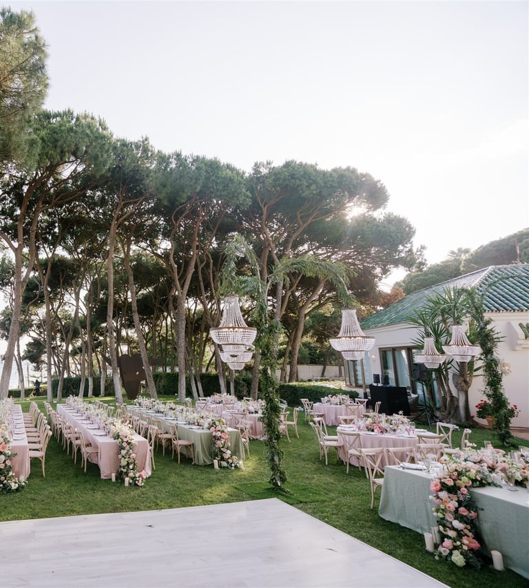 Seaside wedding reception setup at Villa El Rincon Marbella with chandeliers and floral décor