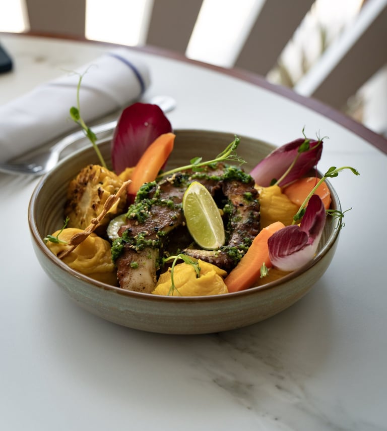 Une assiette de tentacule de poulpe braisé et petits légumes