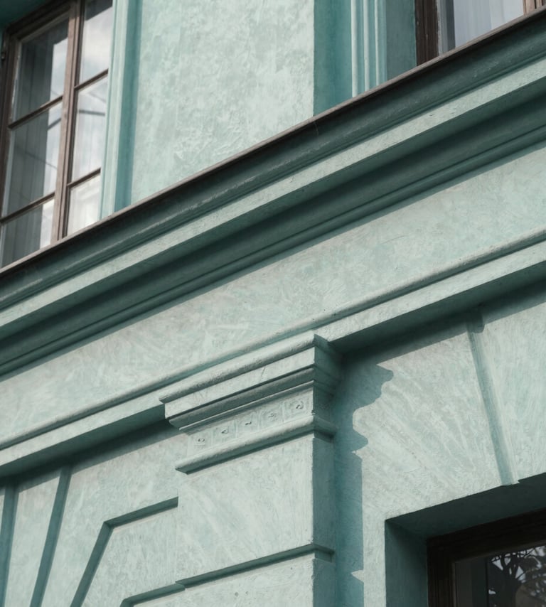 A close-up photograph of a vintage architectural detail with clean lines, shot in natural daylight. The palette features Muted Teal and Soft Sage tones against a Pale Frost building surface, showing texture and historical depth with professional focus.