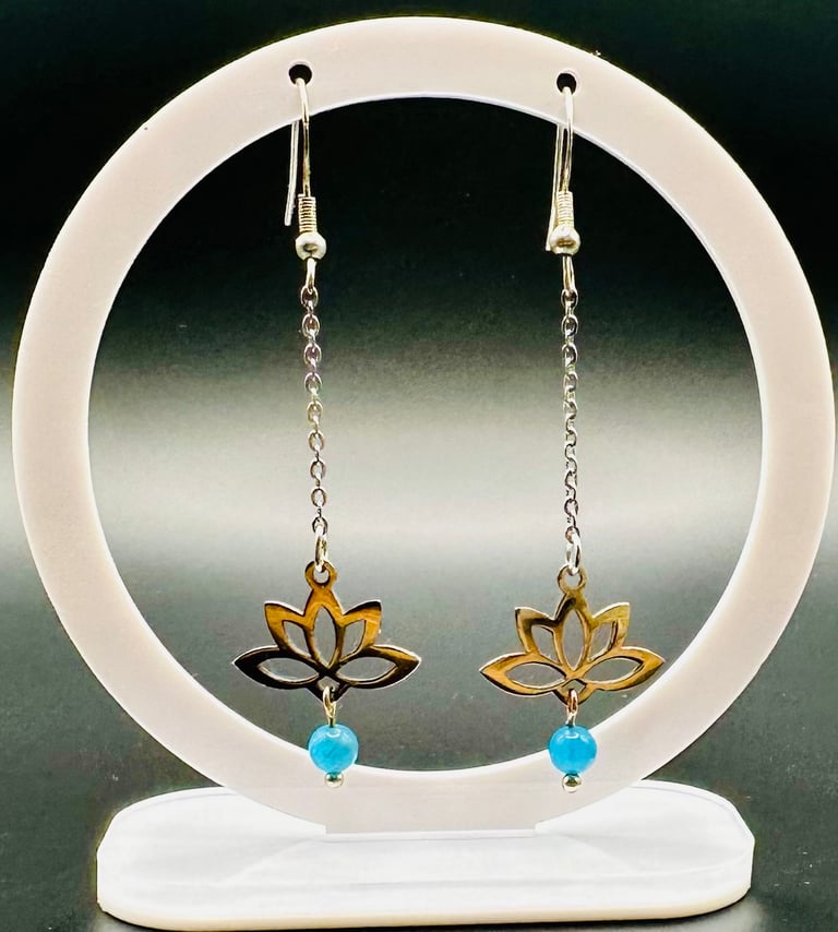 a pair of earrings with a gold and blue flower