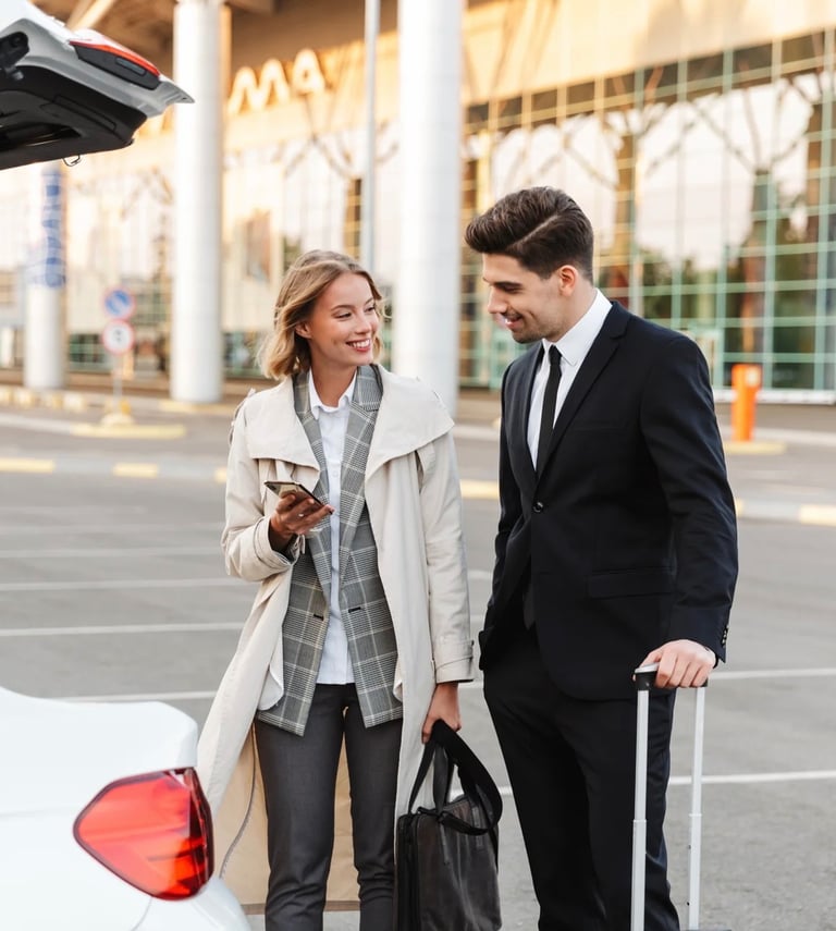 a man and woman standing in front of a car