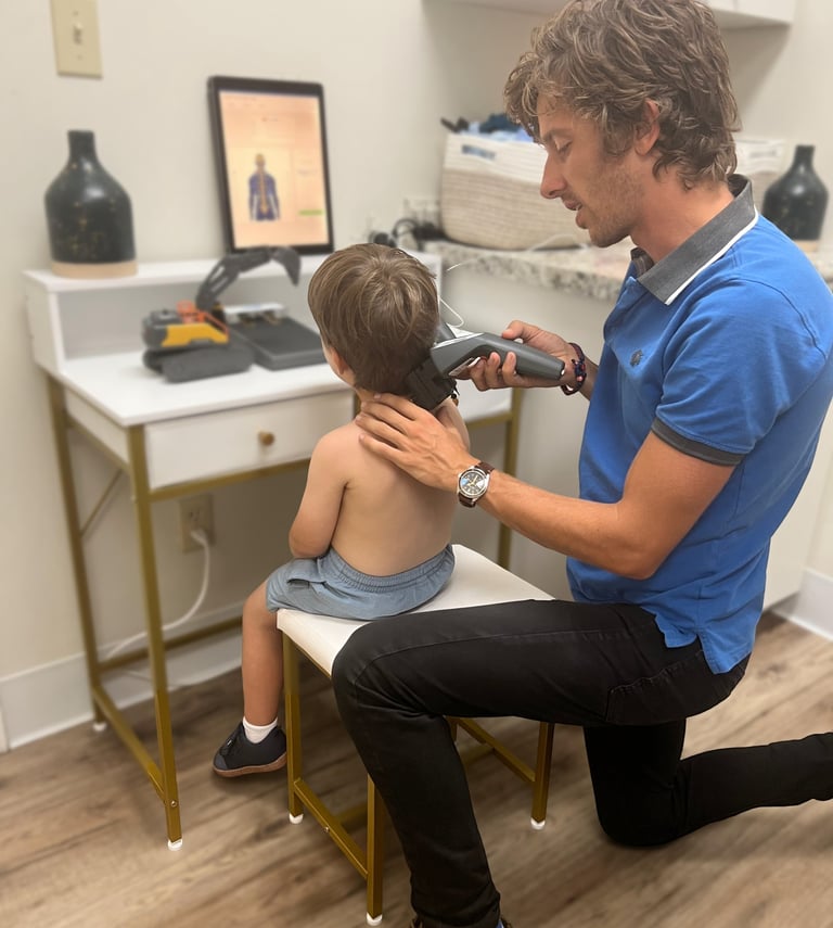 Franklin chiropractor doing insight scans on a small child to find subluxations