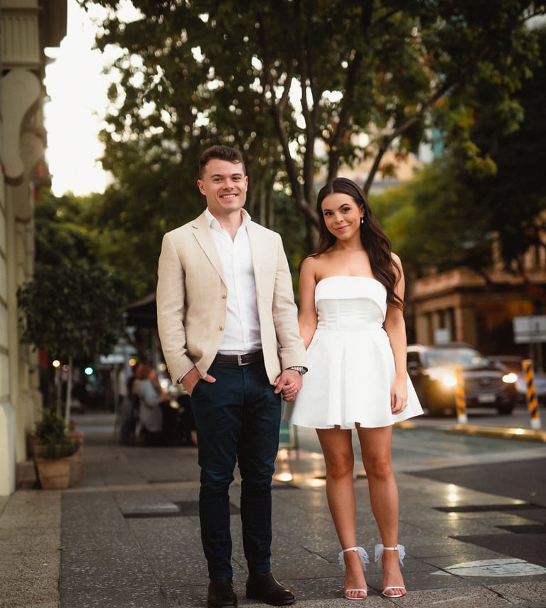 a man and woman holding hands and walking down the street