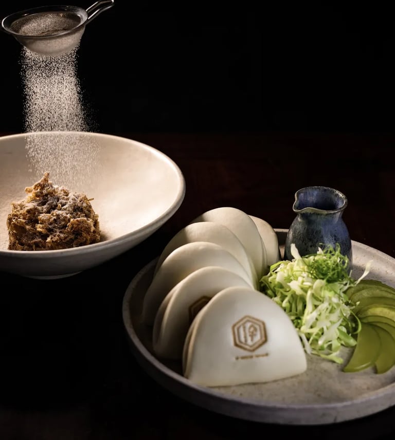 Exquisite bao buns with crispy filling, fresh greens, and sauce, served at Lucky Cat Bishopsgate