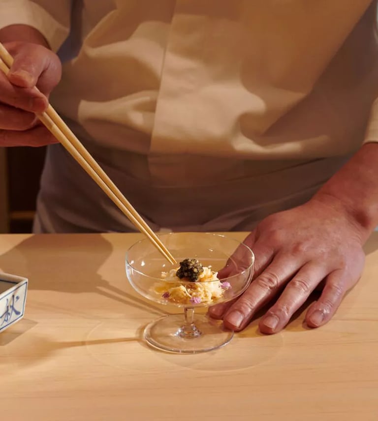 Master chef preparing a luxurious dish with caviar at an omakase dining experience in London.