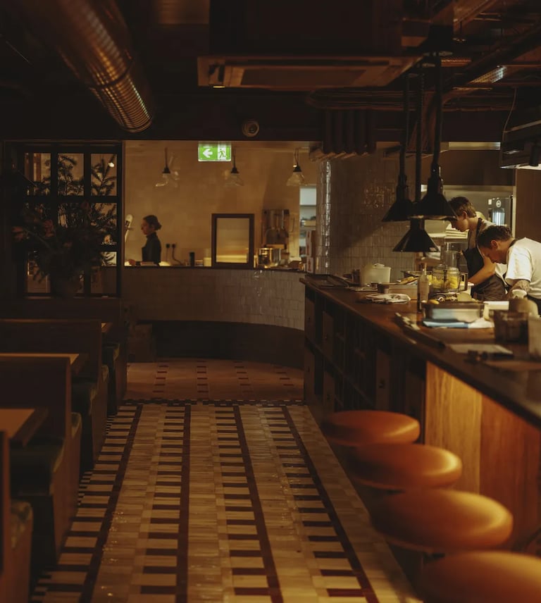 Moody open kitchen at Don't Tell Dad, a top London restaurant, where chefs craft exquisite dishes.