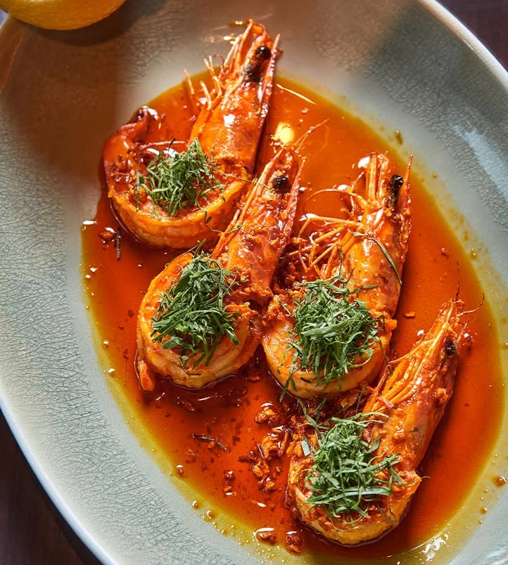 Spicy grilled prawns with fresh herbs and citrus, served in a rich sauce at The Emory Hotel.