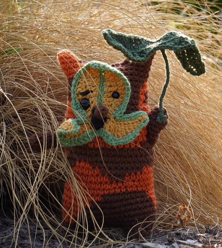 A korok holding a leaf standing in a bush.