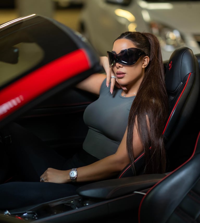 Model sitting inside a red Ferrari car wearing sunglasses, captured by Fred Art Studio.