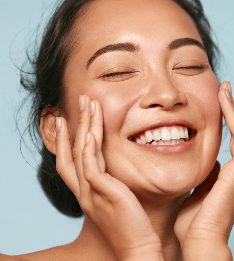 A lady smiling with glowing skin 