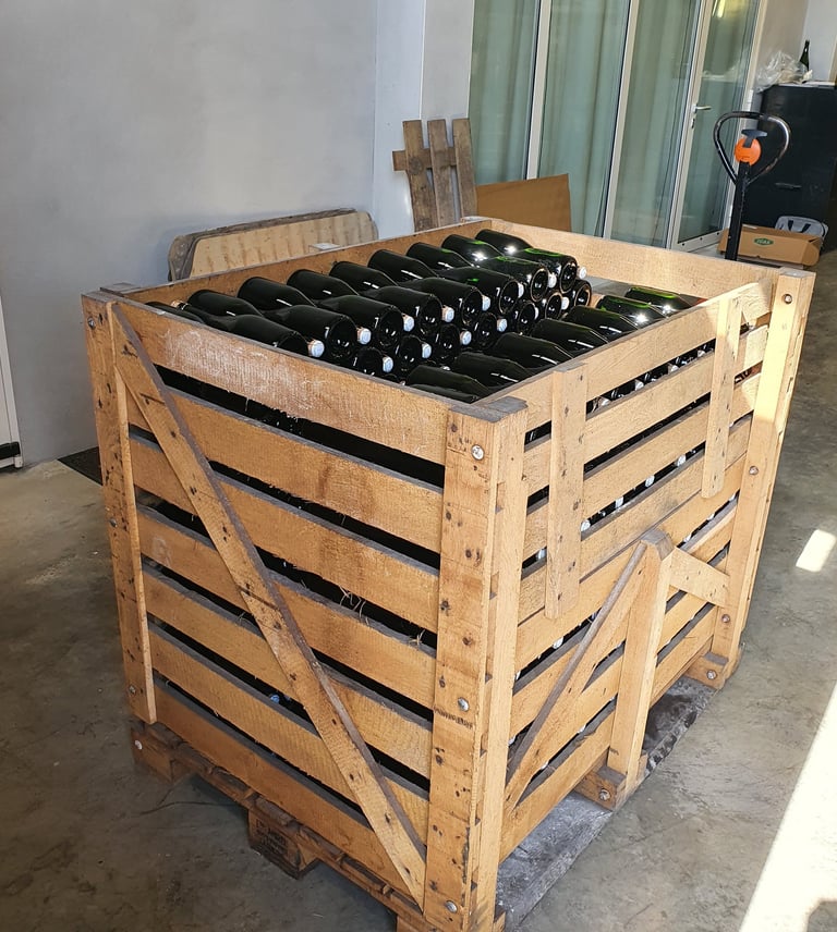 Palette en bois chargée complétement de bouteilles de Champagne La Bulle du Bassin