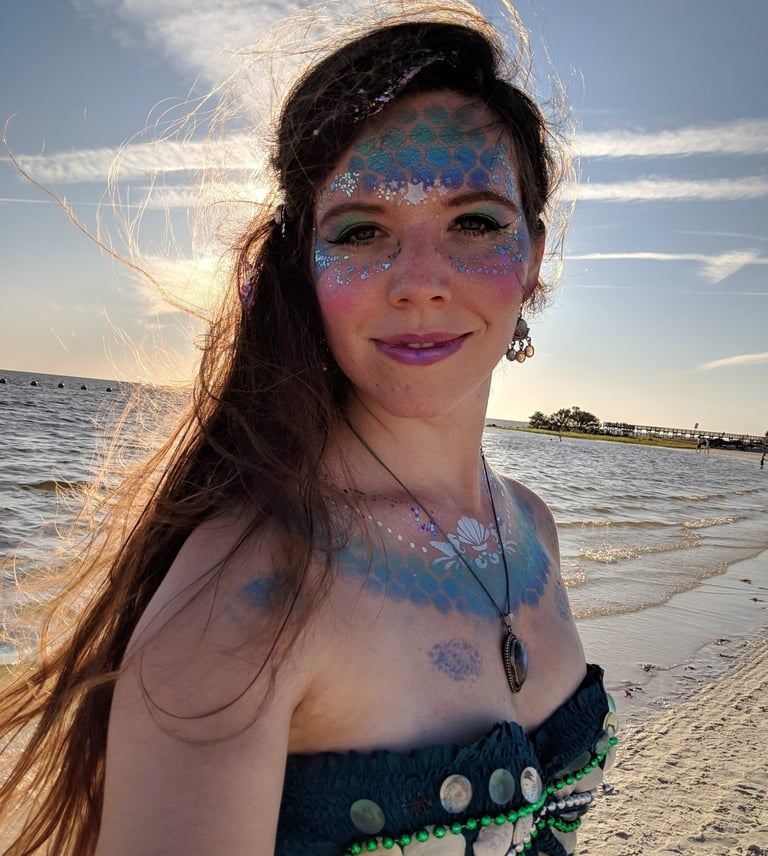 MerMapp's CEO Coraluna lit from behind by the sun, on a beautiful beach.