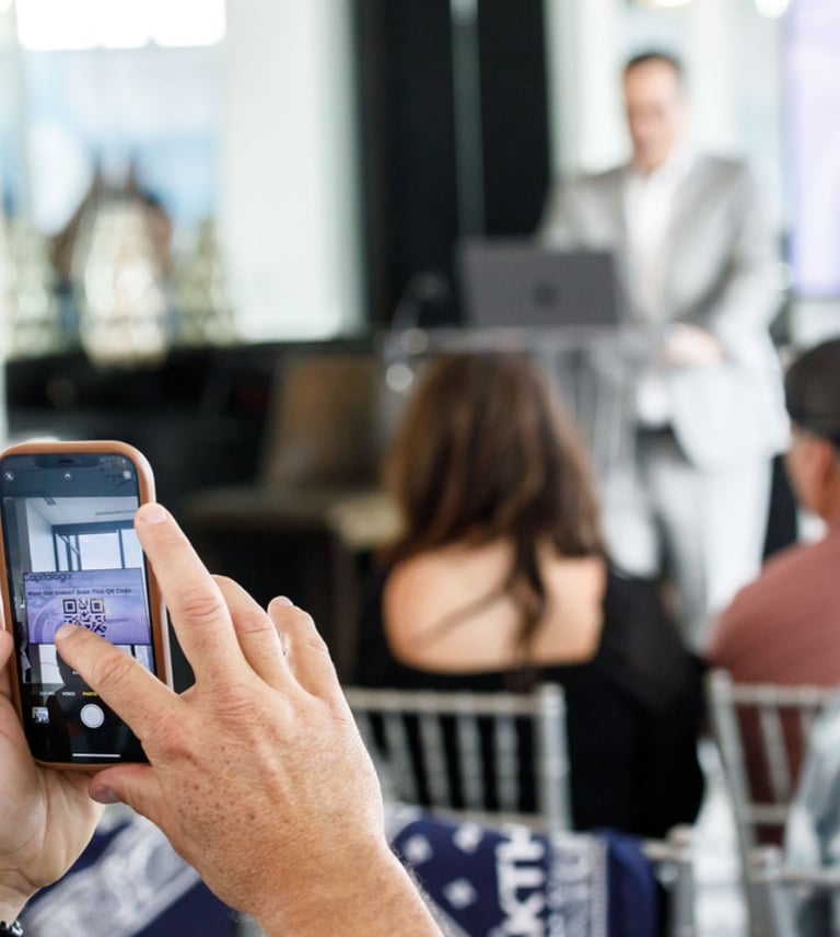 a man is taking a photo of a speaker at a business meeting