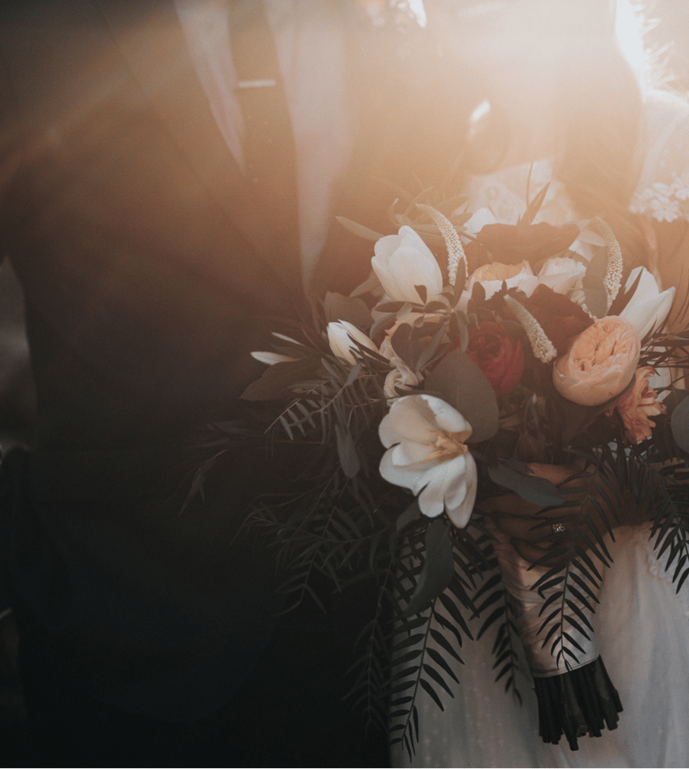 a bride and groom holding a bouquet of flowers