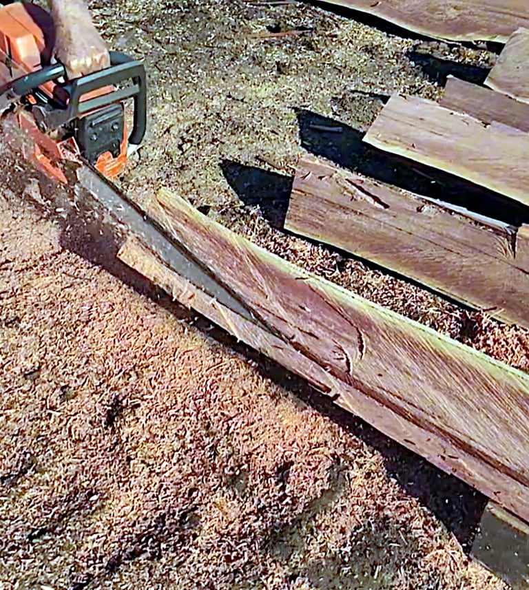 Facing fence post with chainsaw