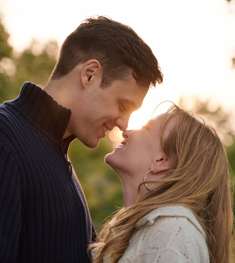 a man and woman are kissing in front of the sunset