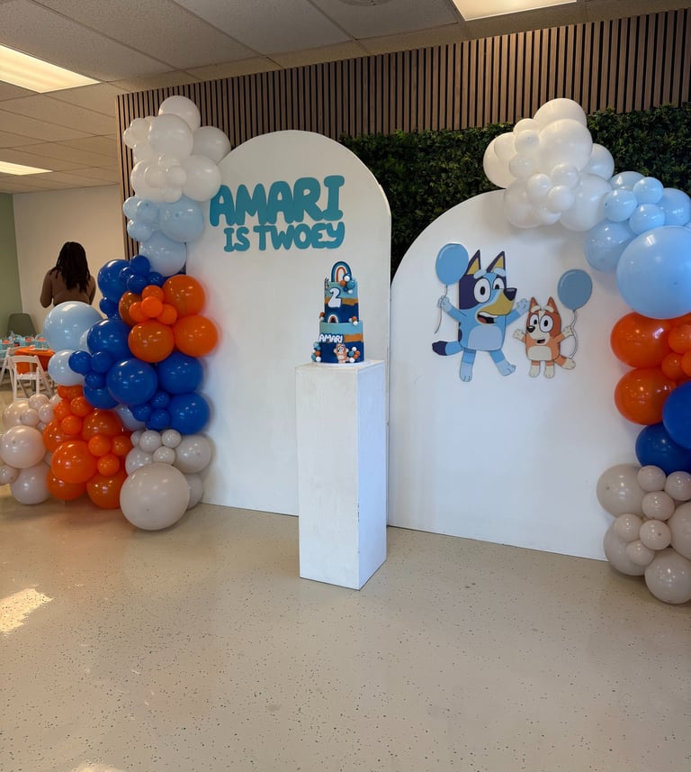 a party with bluey decor and a balloon arch