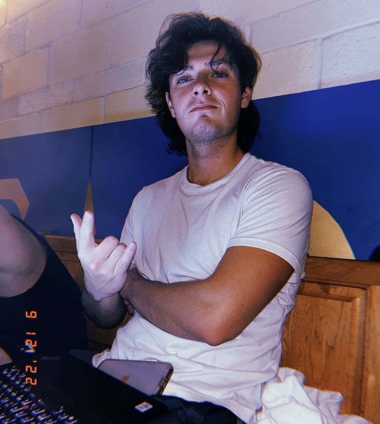 Image of Kevin Bockius, Mechanical Engineer, smiling for picture while working on laptop