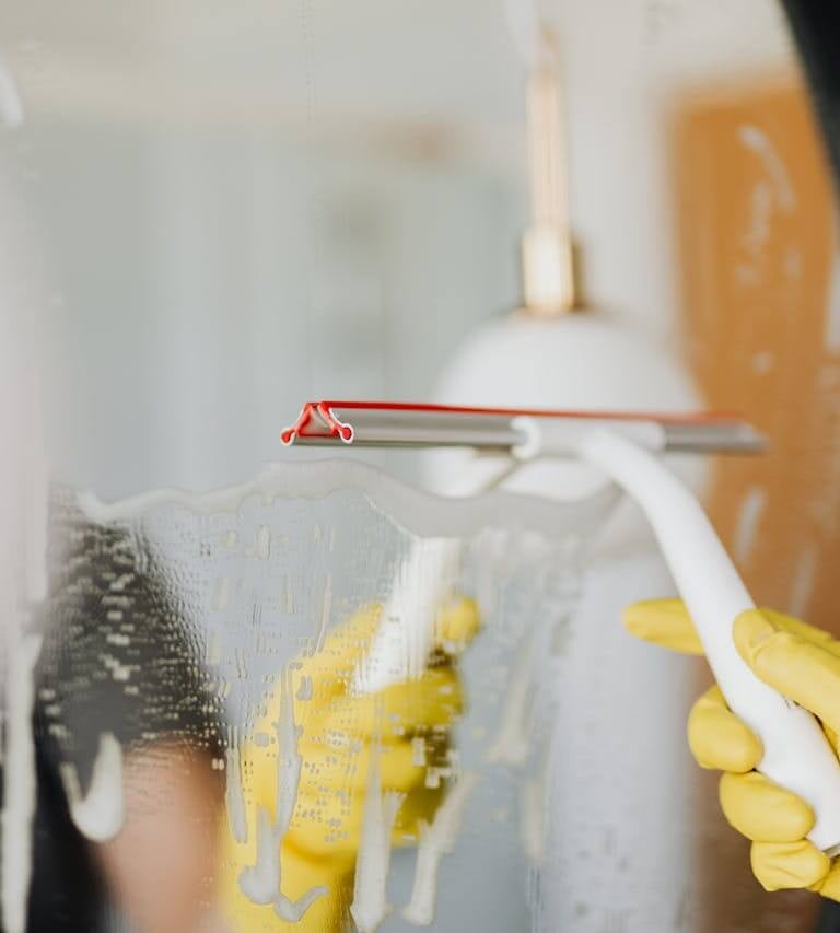 wiping mirror during home cleaning service