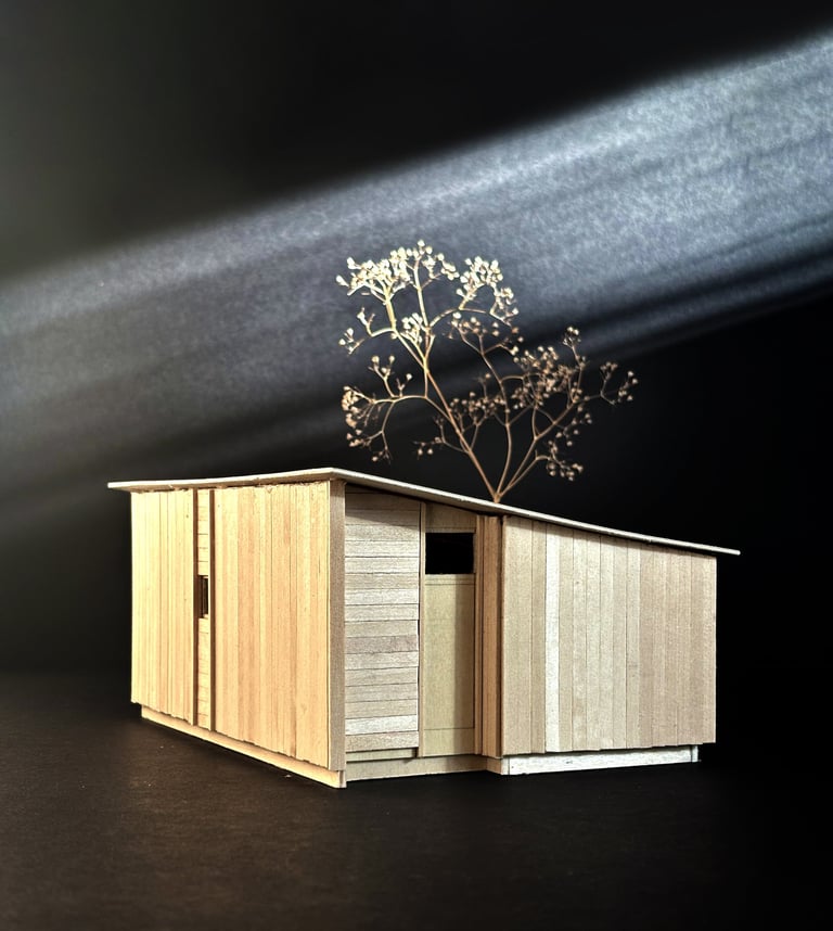 Handcrafted basswood architectural model of a modern cabin design against a dark background.