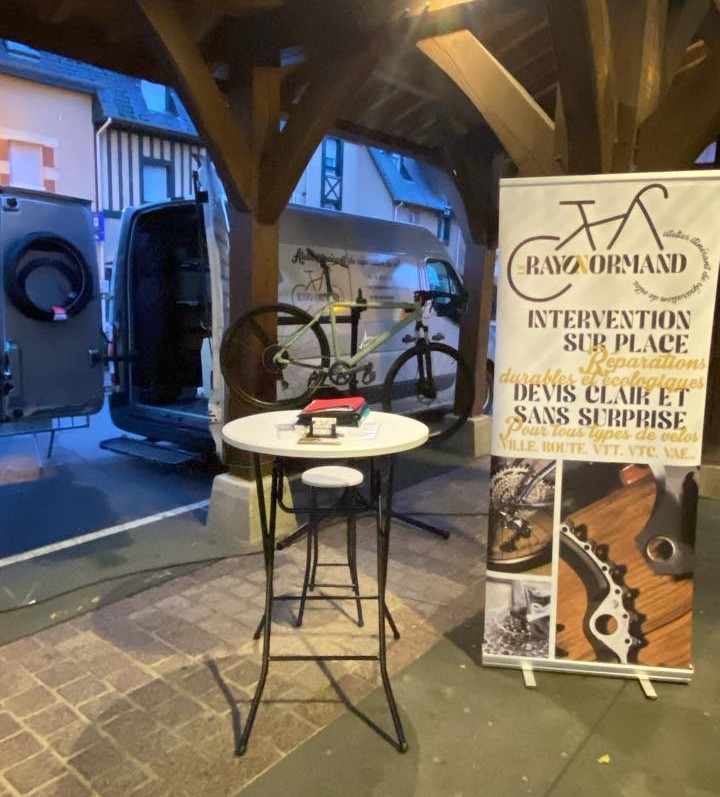 camionnette et stand installés sur la place du marché de la ville de touque