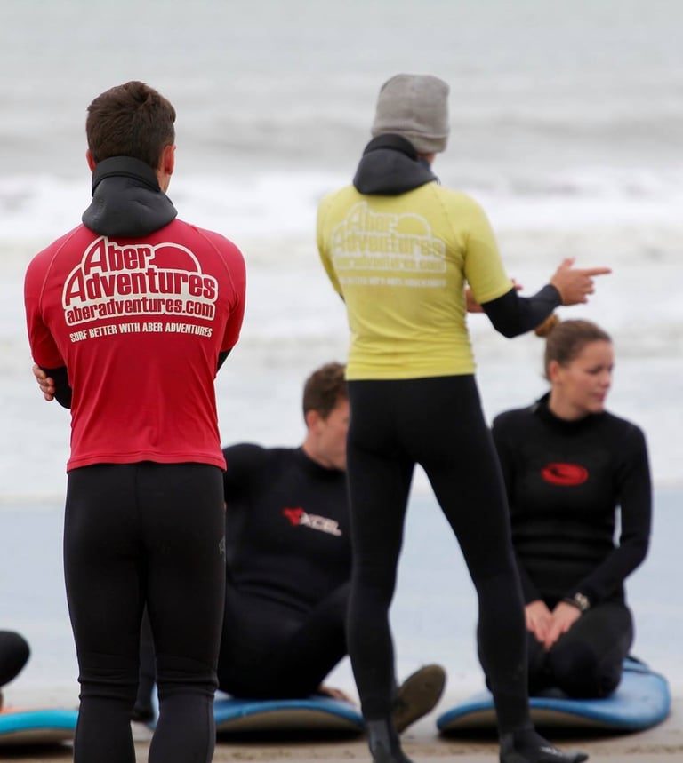 two surf coaches giving a safety brief while group listens.