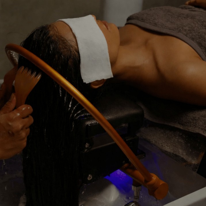 Rituel capillaire japonais : eau en cascade sur le cuir chevelu et manœuvres de massage relaxantes.