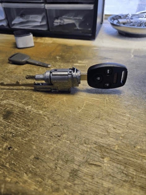 Car key fob and ignition cylinder on a workbench