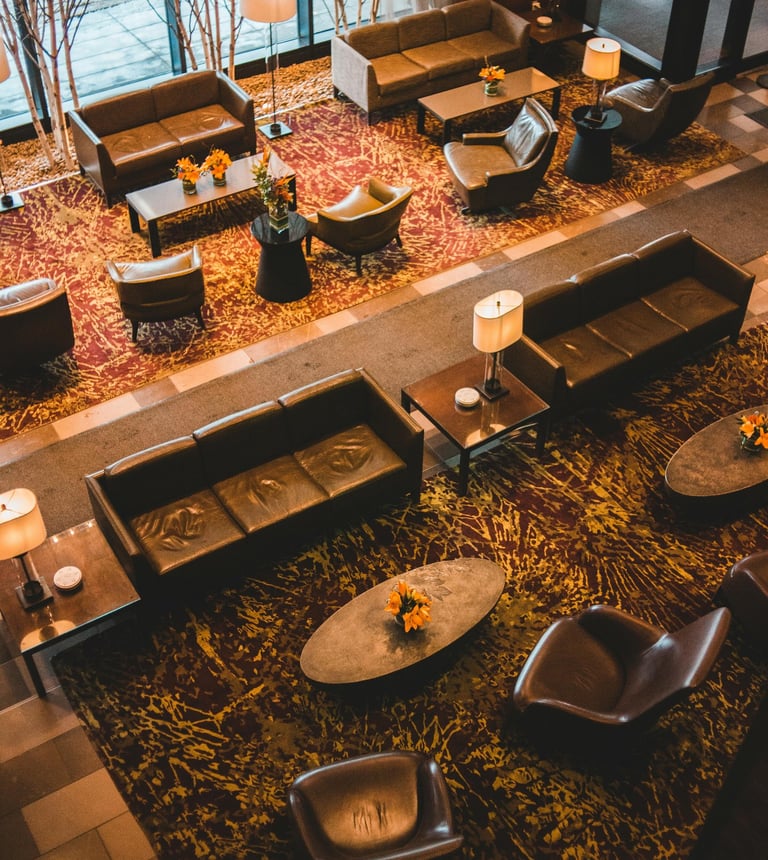 Luxury hotel lobby lounge with leather sofas, designer armchairs, and warm ambient lighting.