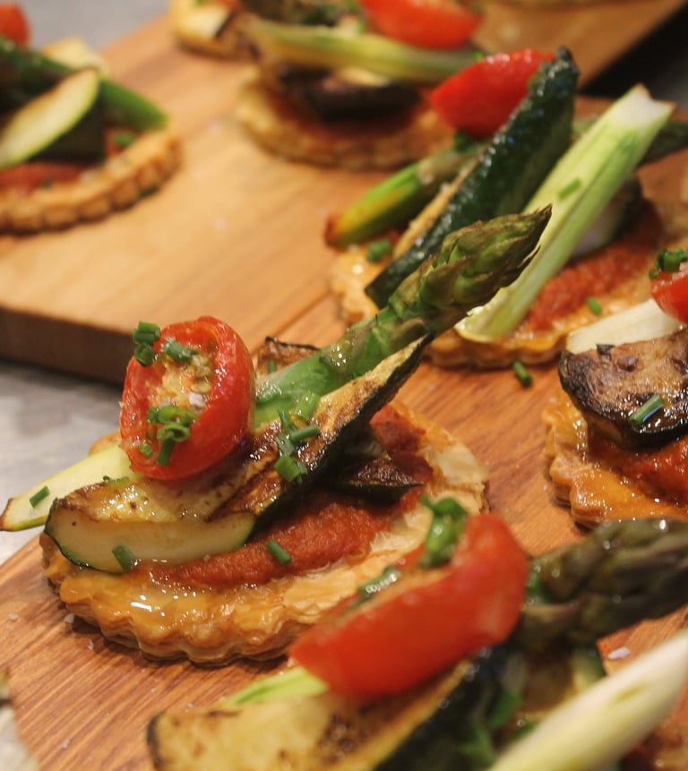 a wooden board with a variety of vegetables tart