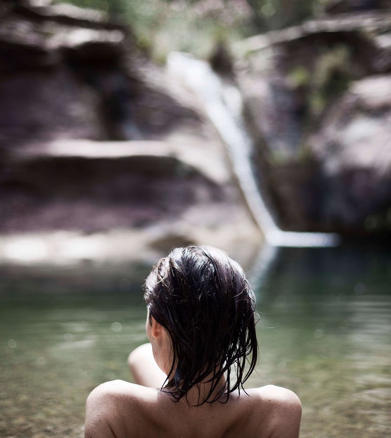 Mujer disfrutando de un baño en Pozo Negro, experiencia natural cerca de La Calma, Castellón