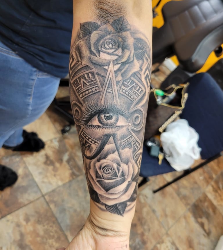 Tatuaje realista rosa y calendario azteca con ojo al centro, Detroit Aztec Tattoo Leon Guanajuato, resena cliente 