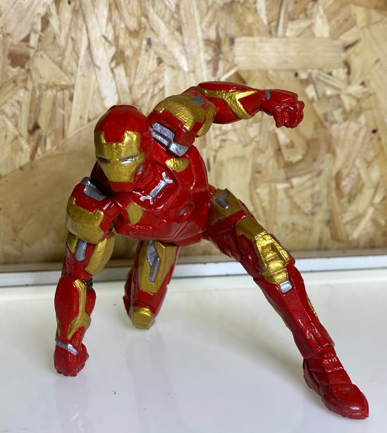 a toy iron man figure with a red and gold suit