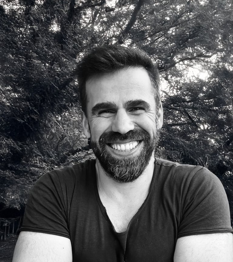 Adnan Erzen, Tai Ji and Qi Gong instructor at WDP Türkiye, smiling outdoors in a forest setting.