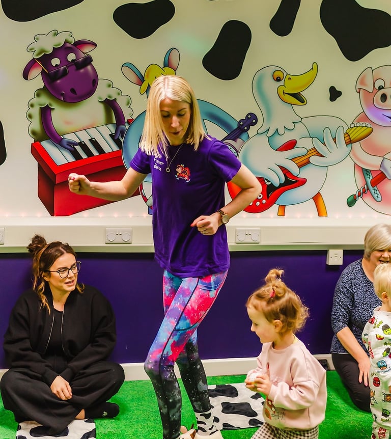 Action shot of Farmer Becca in the Moo Room dancing with a child.