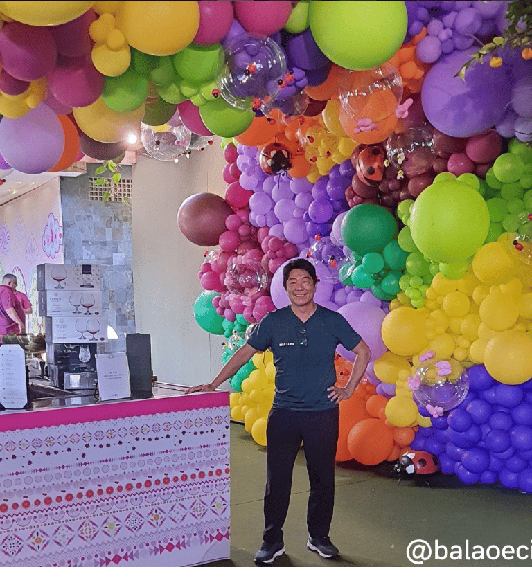a man standing in front of a large display of balloons